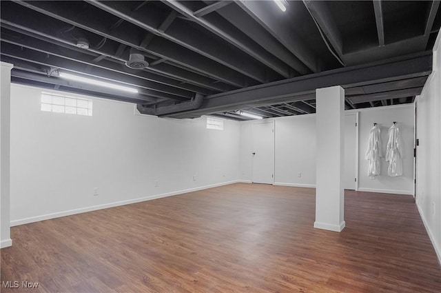 below grade area featuring baseboards and wood finished floors