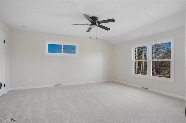 unfurnished room with visible vents, baseboards, light colored carpet, and a textured ceiling