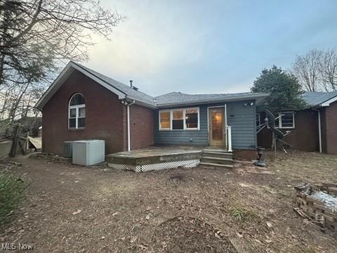 back of property featuring a wooden deck and cooling unit