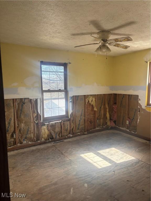 unfurnished room featuring a textured ceiling and a ceiling fan