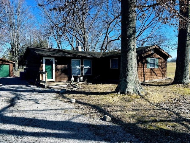 view of front of home with driveway and an outdoor structure