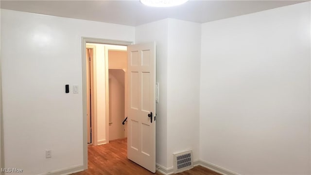 unfurnished room with visible vents, baseboards, and wood finished floors