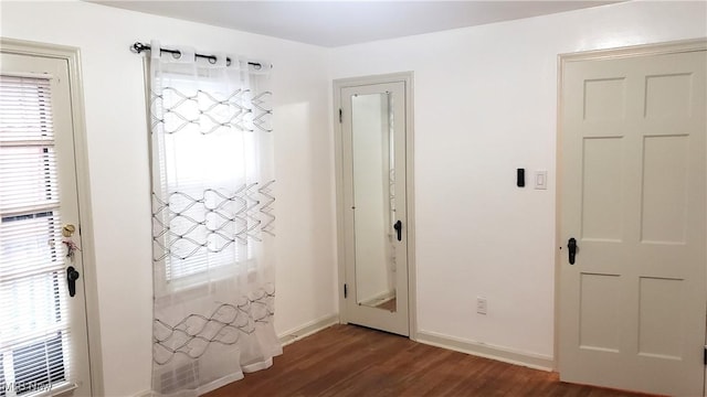 interior space featuring baseboards and dark wood-style floors