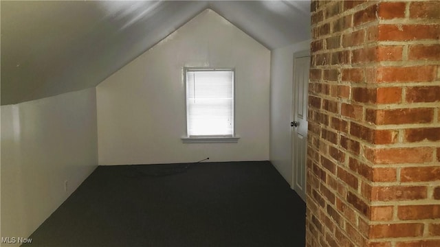 additional living space with brick wall and vaulted ceiling