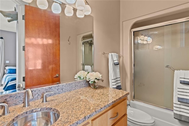 full bathroom with vanity, toilet, and bath / shower combo with glass door