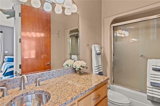 bathroom featuring enclosed tub / shower combo, toilet, ensuite bath, and vanity