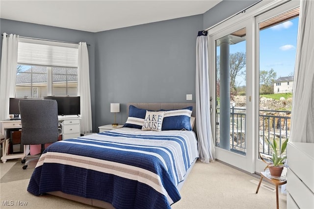 bedroom with access to outside, multiple windows, and carpet floors