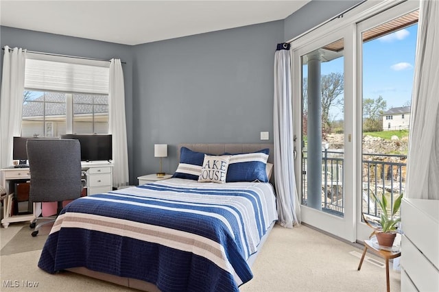 bedroom featuring multiple windows, carpet, and access to outside