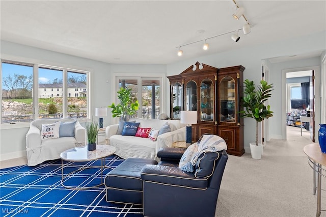 carpeted living area with baseboards