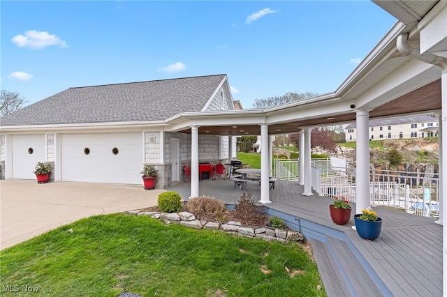 view of side of property featuring concrete driveway, a garage, and a shingled roof