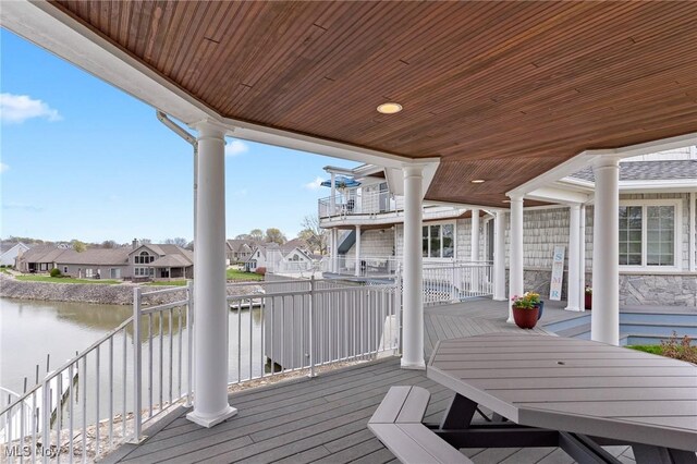 wooden terrace with a residential view and a water view