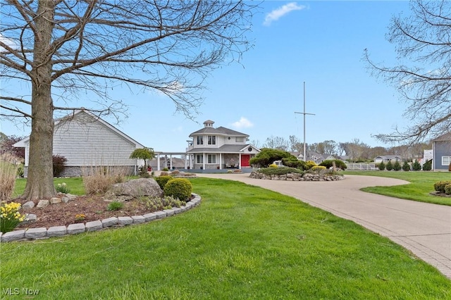 exterior space featuring concrete driveway and a front lawn