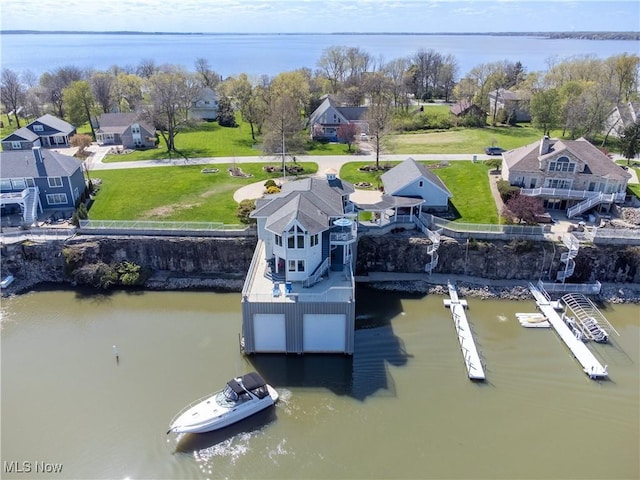 view of dock featuring a yard, a water view, and a residential view