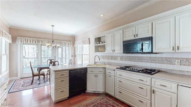 kitchen with black appliances, ornamental molding, a sink, wood finished floors, and light countertops