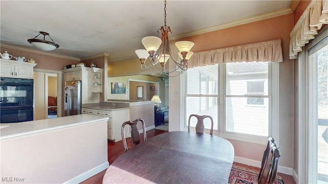 dining space with ornamental molding, a wealth of natural light, and a chandelier