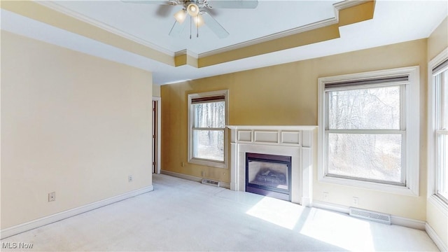 unfurnished living room featuring visible vents, a ceiling fan, a fireplace, and crown molding