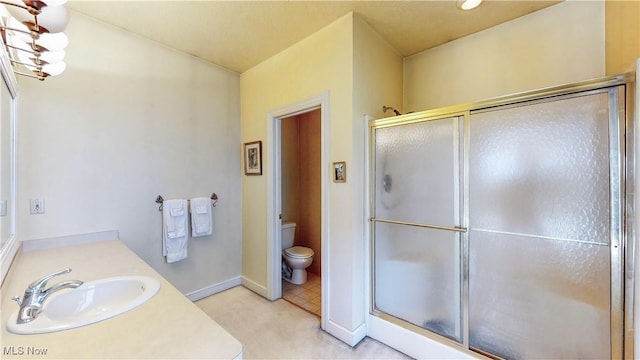 full bath featuring vanity, baseboards, an inviting chandelier, a stall shower, and toilet