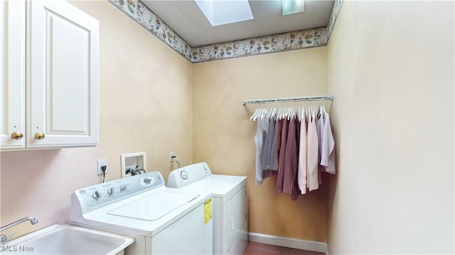 clothes washing area featuring baseboards, a skylight, cabinet space, a sink, and washing machine and dryer