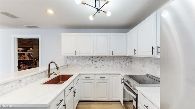 kitchen with light stone countertops, visible vents, a sink, range with electric stovetop, and white cabinetry