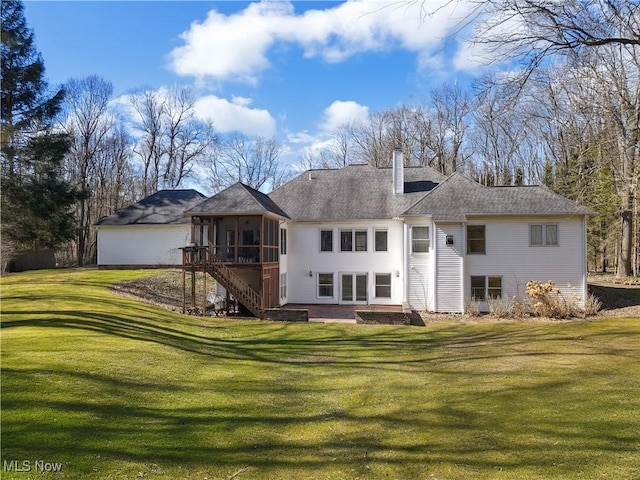 rear view of property featuring a sunroom, a shingled roof, stairs, a chimney, and a lawn