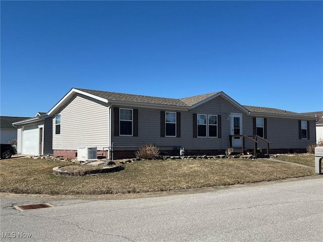 view of front facade with a garage and central AC unit