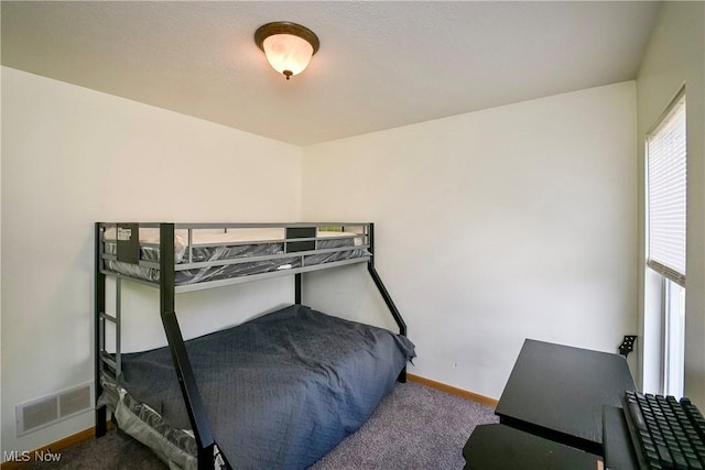 carpeted bedroom featuring visible vents and baseboards