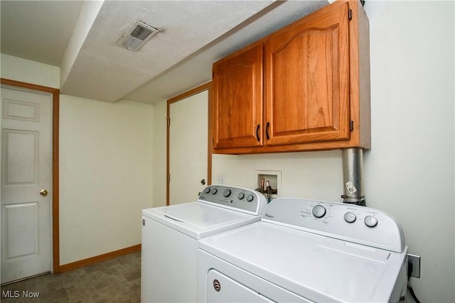 clothes washing area featuring visible vents, baseboards, cabinet space, washer and dryer, and tile patterned floors