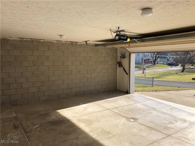 garage with concrete block wall and a garage door opener