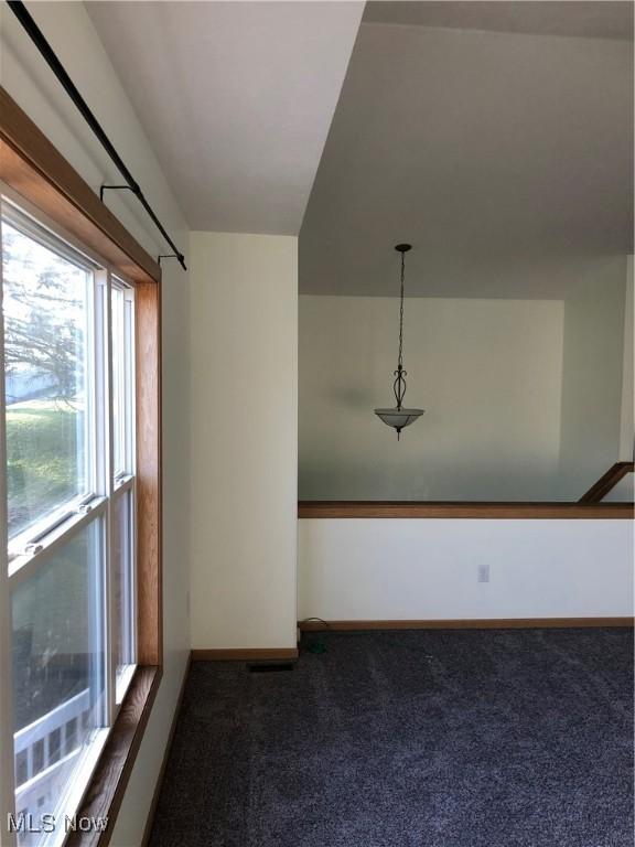 spare room featuring baseboards and carpet floors