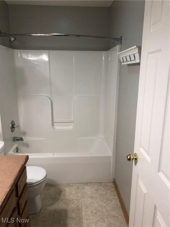 bathroom featuring tile patterned floors, shower / washtub combination, toilet, and vanity