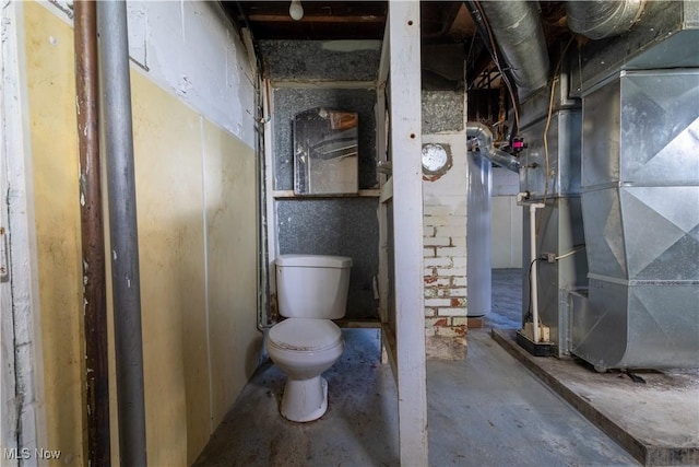 bathroom featuring heating unit, toilet, and unfinished concrete flooring