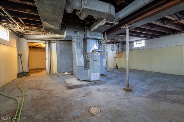 basement featuring heating unit and water heater