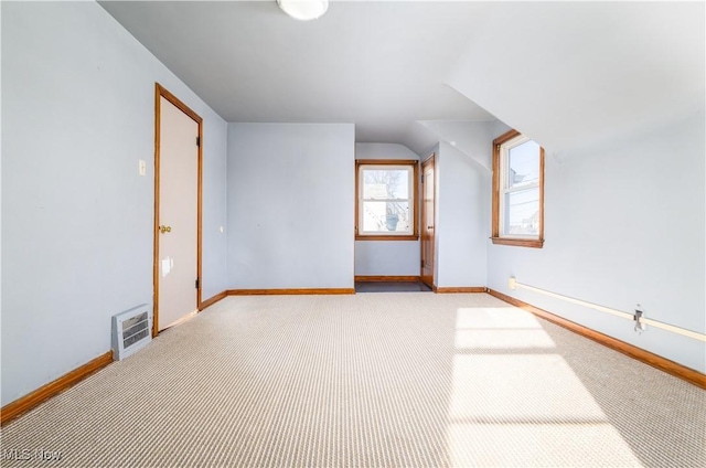 bonus room featuring heating unit, light colored carpet, lofted ceiling, and baseboards