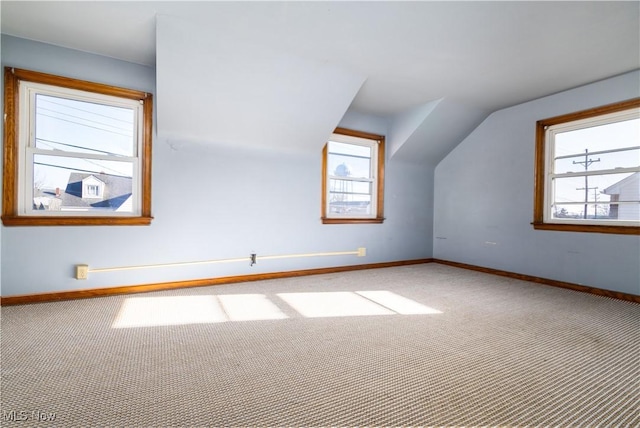 additional living space with baseboards, carpet, and lofted ceiling