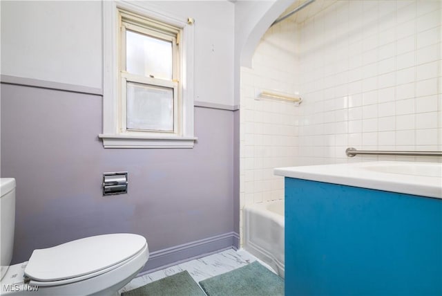 bathroom with toilet, a tub, baseboards, walk in shower, and vanity