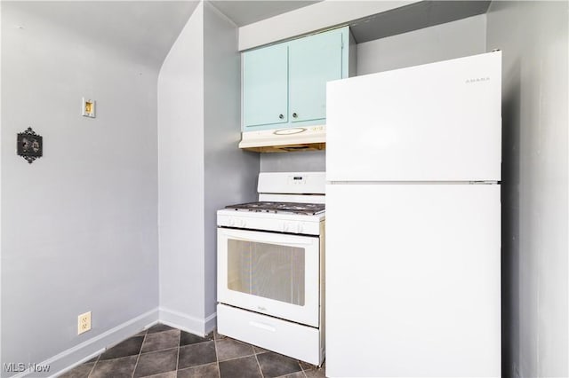 kitchen featuring white appliances, baseboards, dark tile patterned flooring, under cabinet range hood, and blue cabinets