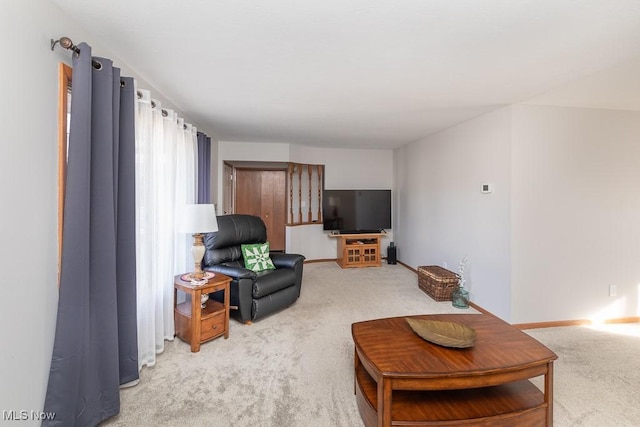 living room featuring baseboards and light carpet