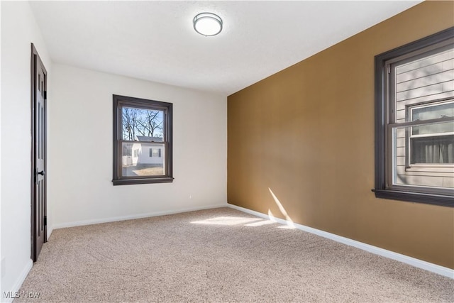 carpeted spare room with baseboards