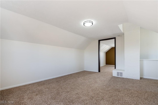 additional living space featuring visible vents, baseboards, carpet, and vaulted ceiling