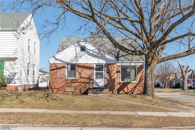 view of front of house with brick siding and a front yard