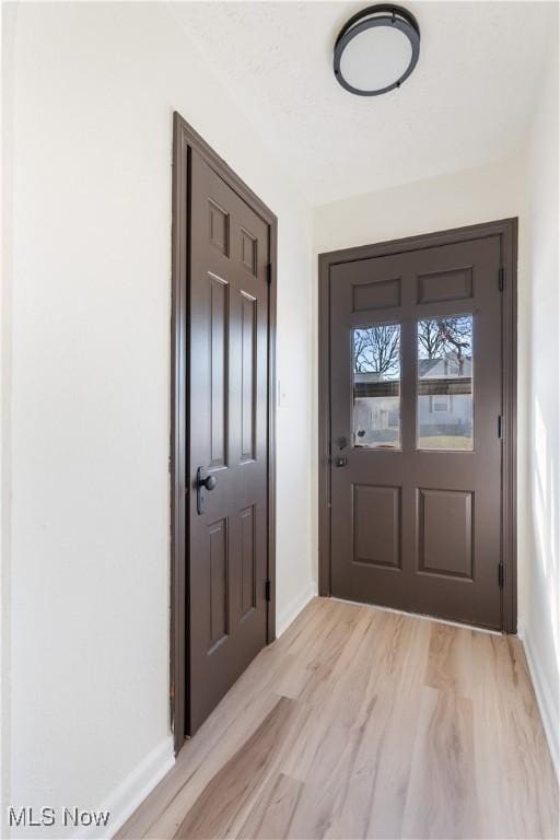 entryway featuring light wood-type flooring and baseboards