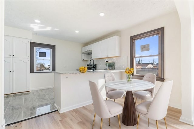 dining room featuring recessed lighting, baseboards, and light wood finished floors