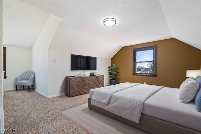 bedroom with carpet flooring, baseboards, and vaulted ceiling