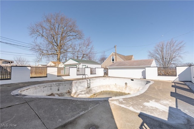 view of pool with a fenced front yard, an empty pool, and a patio area