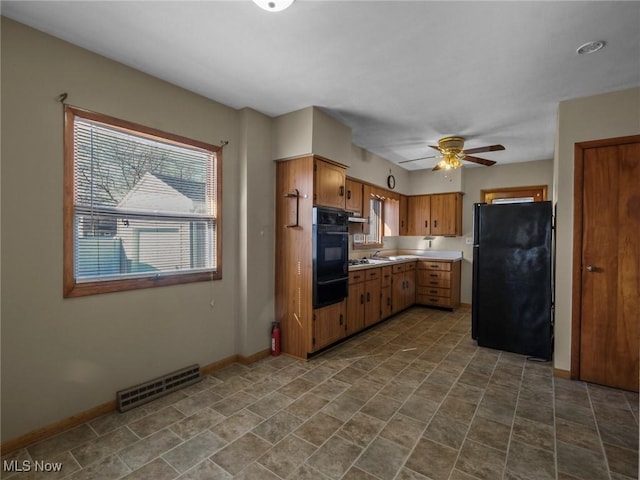 kitchen with visible vents, black appliances, light countertops, and baseboards