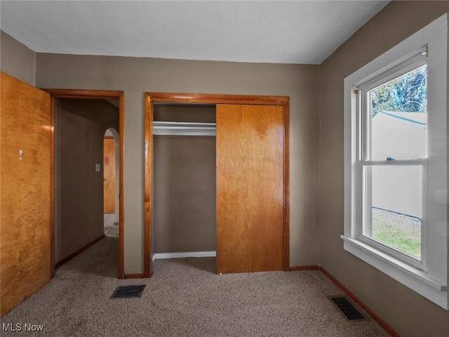 unfurnished bedroom featuring a closet, visible vents, and multiple windows