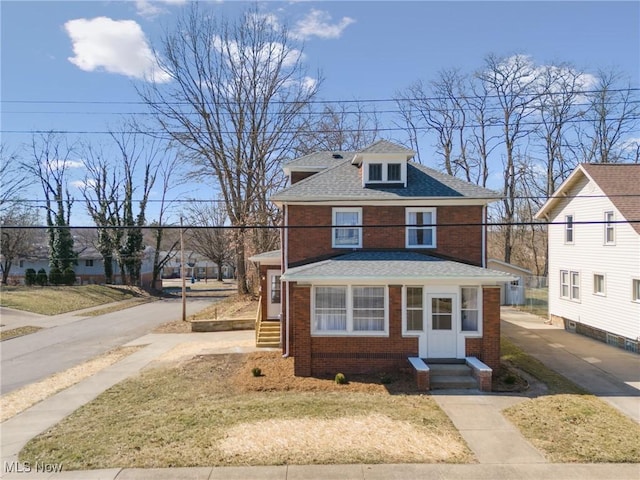 traditional style home with brick siding and a shingled roof