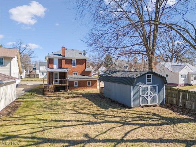 exterior space with an outbuilding, fence, a residential view, and a shed