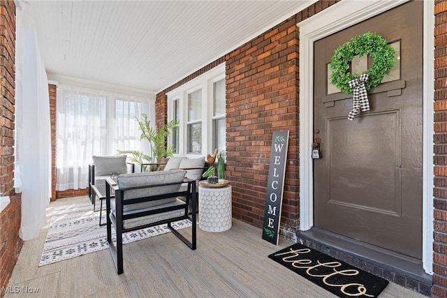 entrance to property featuring brick siding and a porch