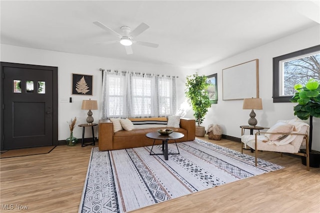 living room featuring wood finished floors, a healthy amount of sunlight, and baseboards